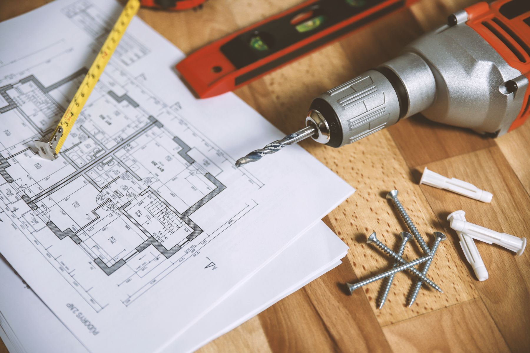 Architectural floor plans with measuring tools on a workbench